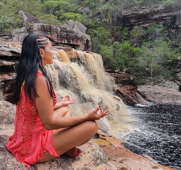 Mulher meditando em frente à Cachoeira das Andorinhas